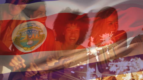 Animation-Der-Flagge-Von-Costa-Rica-über-Verschiedenen-Freunden-Mit-Wunderkerzen,-Die-Am-Strand-Spaß-Haben