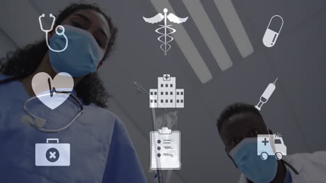 Animation-Digitaler-Symbole-über-Verschiedenen-Ärzten-Mit-Gesichtsmasken-Im-Krankenhaus