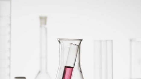 Video-Eines-Laborreagenzglases-Aus-Glas-Mit-Rosa-Flüssigkeit-Im-Becher-Mit-Kopierraum-Auf-Weißem-Hintergrund