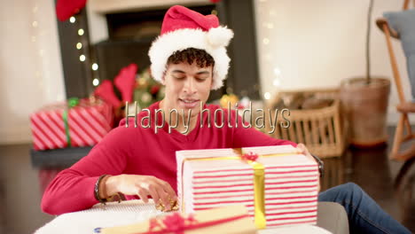 Animation-of-happy-holidays-text-over-caucasian-man-wrapping-christmas-presents