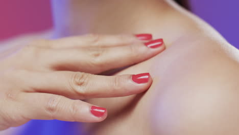 Asiatische-Frauenhand-Mit-Roten-Nägeln-Berührt-Schulter,-Kopierraum,-Zeitlupe