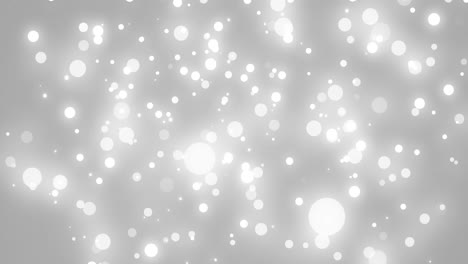 Animation-of-white-glowing-spots-falling-on-grey-background