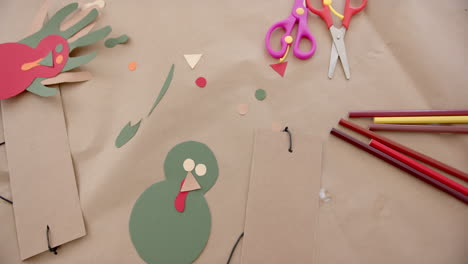 Coloured-paper,-crayons,-scissors-and-cutouts-lying-on-table