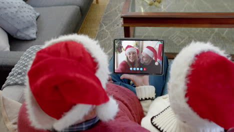 Two-happy-caucasian-couples-having-christmas-tablet-video-call,-slow-motion