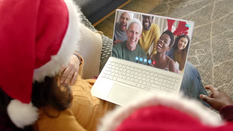 Glückliches,-Vielfältiges-Paar-Und-Eine-Gruppe-Von-Freunden,-Die-Zu-Weihnachten-Einen-Laptop-Videoanruf-In-Zeitlupe-Machen