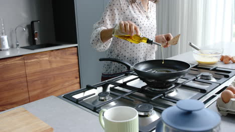 Happy-biracial-couple-cooking-and-preparing-breakfast-in-kitchen,-slow-motion