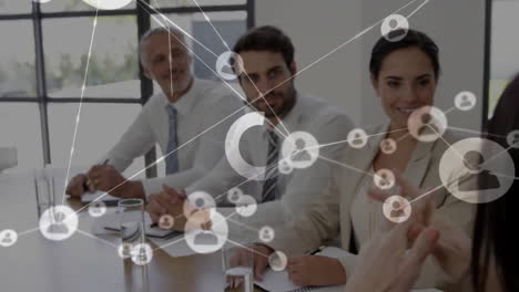 Animation-of-loading-circles-and-connected-icons-over-diverse-coworkers-discussing-reports-in-office