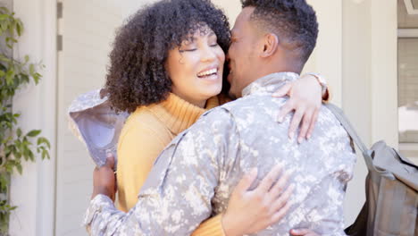 Glücklicher-Afroamerikanischer-Soldat-Umarmt-Seine-Tochter-Und-Seine-Frau-Zu-Hause,-Zeitlupe