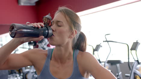 Fit-young-Caucasian-woman-hydrates-during-a-gym-workout