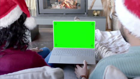 Happy-diverse-couple-having-christmas-laptop-video-call-with-green-screen,-slow-motion