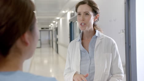 Diverse-female-doctors-discussing-in-hospital-corridor,-slow-motion
