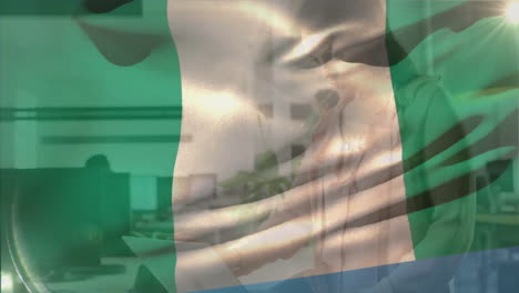 Animación-De-La-Bandera-De-Nigeria-Ondeando-Sobre-Una-Mujer-De-Negocios-Caucásica-Estudiando-Un-Documento-En-Una-Oficina-Informal