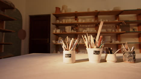 Brushes-and-pottery-tools-on-desk-in-pottery-studio