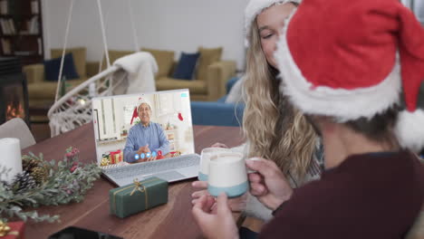 Happy-caucasian-couple-and-senior-male-friend-having-christmas-laptop-video-call,-slow-motion