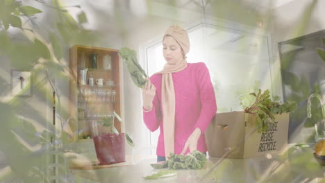 Biracial-woman-in-hijab-looking-at-vegetables-in-kitchen-over-spots-of-light