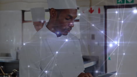 Animation-of-network-of-connections-over-african-american-chef-using-tablet