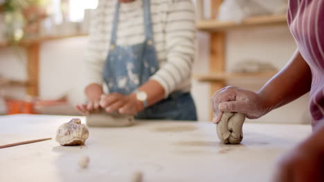 Hands-of-diverse-female-potters-shaping-clay-with-hands-in-pottery-studio,-slow-motion