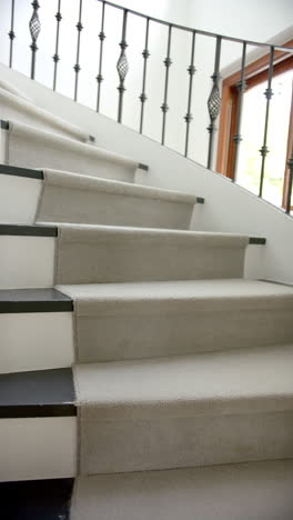 Vertical-video-of-spiral-staircase-in-hallway-of-luxury-home,-slow-motion