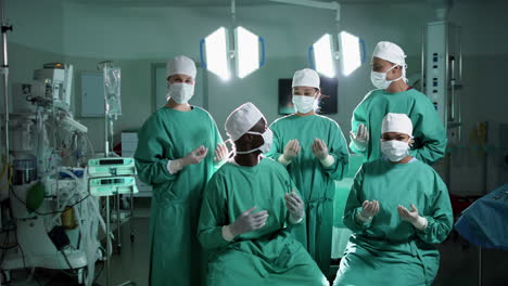 Portrait-of-diverse-surgeons-wearing-surgical-gowns-in-operating-theatre,-slow-motion