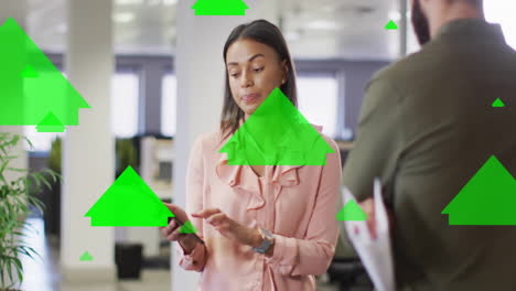Animation-of-green-arrows-processing-over-diverse-business-people-in-office