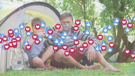 Animation-of-social-media-icons-over-caucasian-father-and-son-sitting-in-tent-in-garden