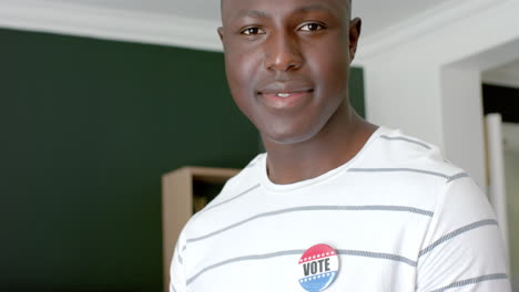 Young-African-American-man-wearing-a-'Vote'-badge
