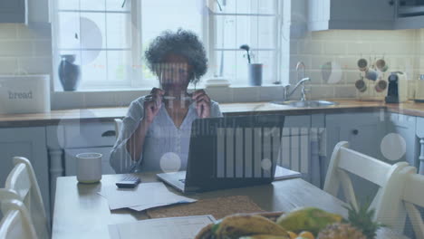 Animation-of-financial-data-processing-over-senior-african-american-woman-using-laptop