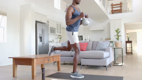 Focused-african-american-man-exercising-with-kettlebell-in-sunny-living-room,-slow-motion