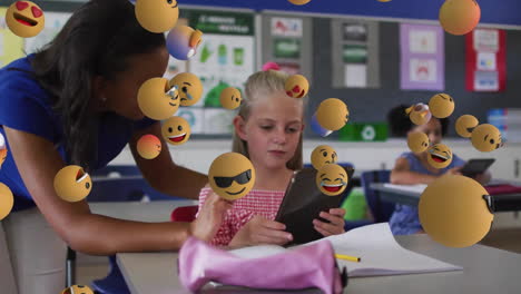 Animation-of-emoji-icons-over-diverse-schoolgirl-and-teacher-using-laptop
