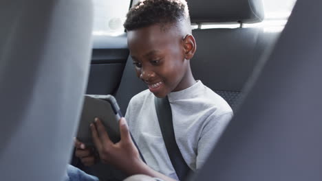 Afroamerikanischer-Junge-Genießt-Ein-Tablet-Auf-Dem-Rücksitz-Eines-Autos