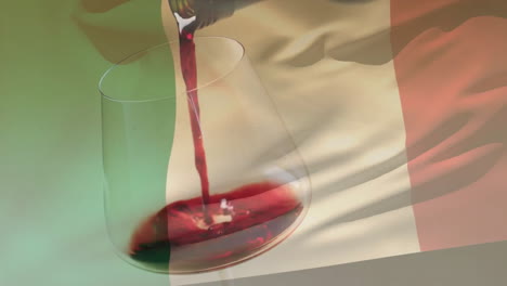 Komposit-Aus-Rotwein,-Der-In-Ein-Glas-Gegossen-Wird,-über-Dem-Hintergrund-Der-Italienischen-Flagge
