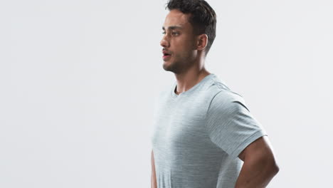 Young-biracial-athlete-man-stands-confidently-in-a-studio-setting-on-a-white-background