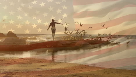 Animación-De-La-Bandera-De-América-Sobre-Un-Hombre-Caucásico-Con-Sombrero-Corriendo-Sobre-Rocas-Con-Pájaros-En-La-Playa-Al-Atardecer