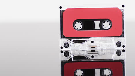 Video-of-retro-cassette-tape-with-red-label-and-reflection-with-copy-space-on-white-background