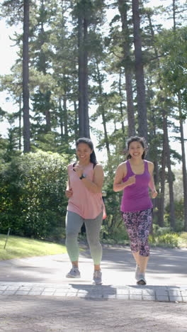Happy-asian-female-friends-running-near-forest-on-on-sunny-day,-slow-motion