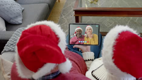 Happy-diverse-senior-couples-having-christmas-tablet-video-call,-slow-motion