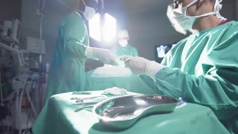 Diversos-Cirujanos-Que-Utilizan-Instrumentos-Quirúrgicos-En-El-Quirófano-Del-Hospital,-Cámara-Lenta