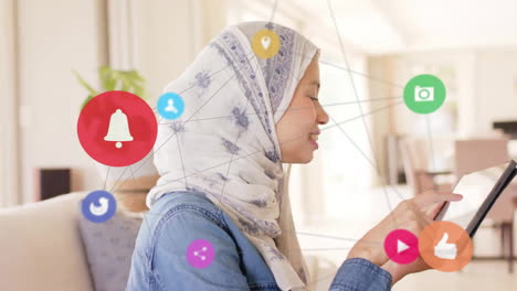 Animation-of-connections-with-icons-over-biracial-woman-in-hijab-using-tablet