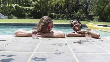 Diverse-couple,-a-young-Caucasian-man-and-an-African-American-woman,-enjoy-poolside-leisure
