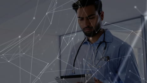 Animation-of-network-of-connections-over-biracial-male-doctor-using-tablet