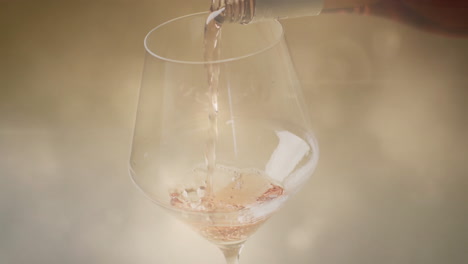 Composite-of-white-wine-being-poured-into-glass-over-spots-of-light-background