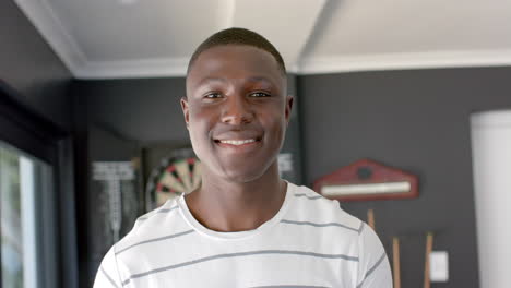 Young-African-American-man-smiles-brightly-at-home