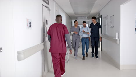 Diverse-healthcare-professionals-walk-in-a-hospital-corridor