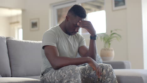 Besorgter-Afroamerikanischer-Soldat,-Der-Im-Sonnigen-Wohnzimmer-Die-Hand-Auf-Den-Kopf-Legt,-Zeitlupe
