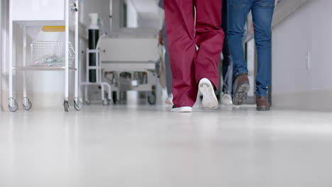 Midsection-of-diverse-male-and-female-doctors-walking-in-hospital-corridor,-slow-motion