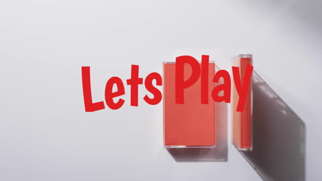 Animation-of-let's-play-text-over-tape-on-white-background
