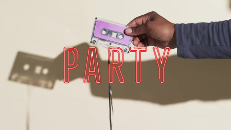 Animation-of-party-text-over-hand-holding-tape-on-beige-background