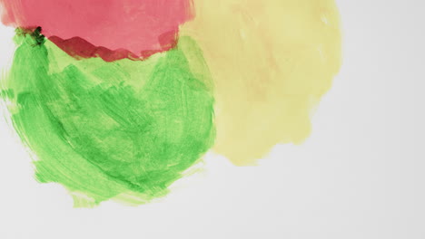 Video-of-red,-yellow-and-green-paints-with-copy-space-on-grey-background