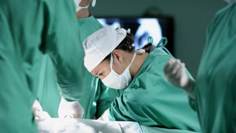 Diverse-male-and-female-surgeons-operating-on-patient-in-operating-theatre-at-hospital,-slow-motion