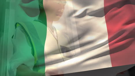 Animation-Einer-Flagge-Italiens,-Die-über-Einem-Asiatischen-Ingenieur-Weht,-Der-Einen-Bauplan-Liest